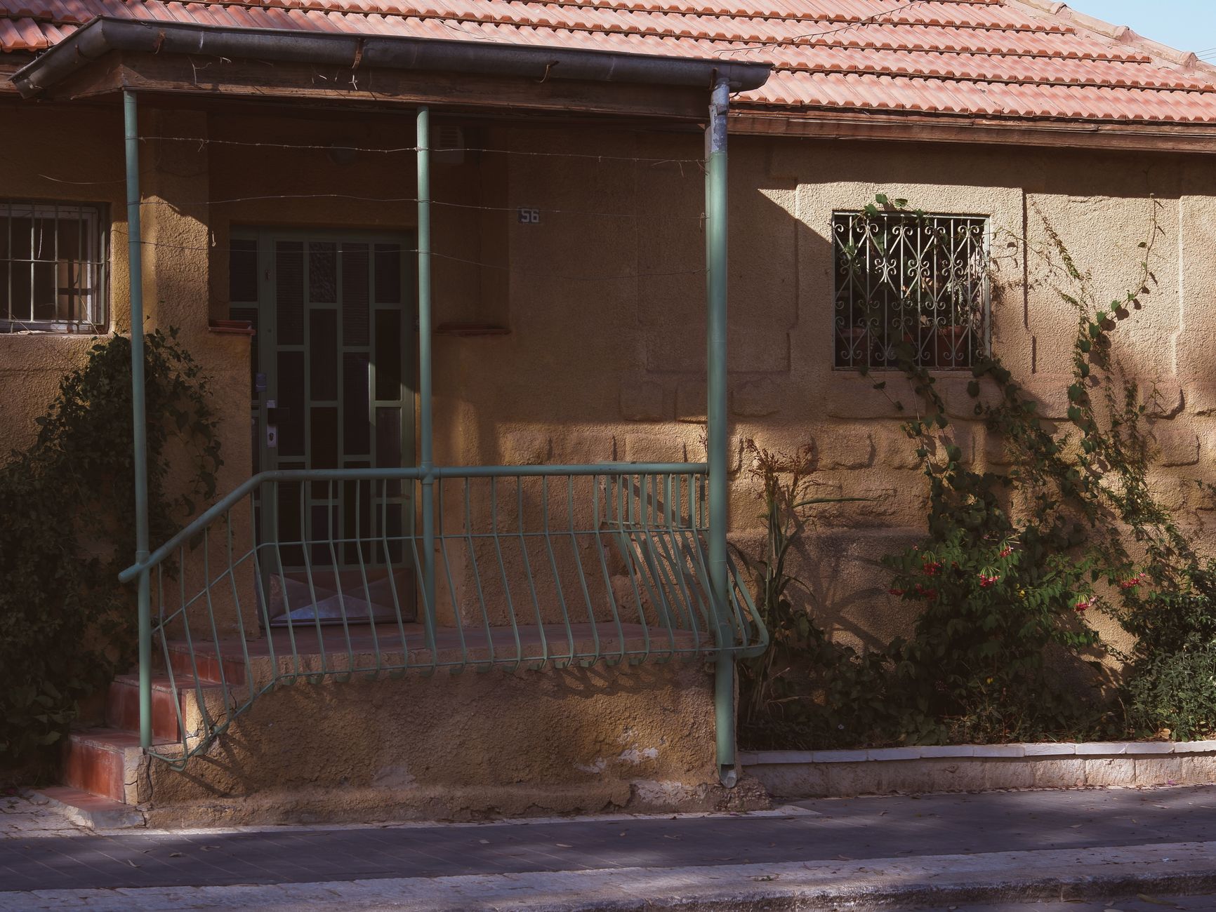 Vine-covered porch with iron railing